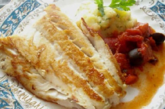 Bacalao con salsa de tomate, aceitunas y chorizo, y papas puré